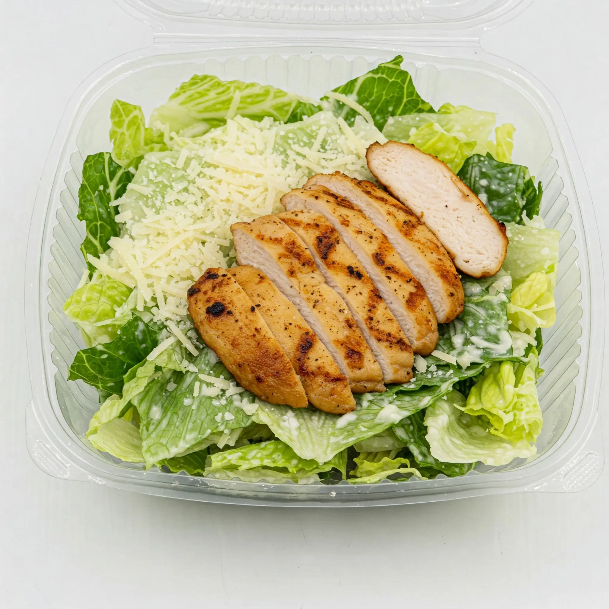 Grilled chicken Caesar salad in plastic container.