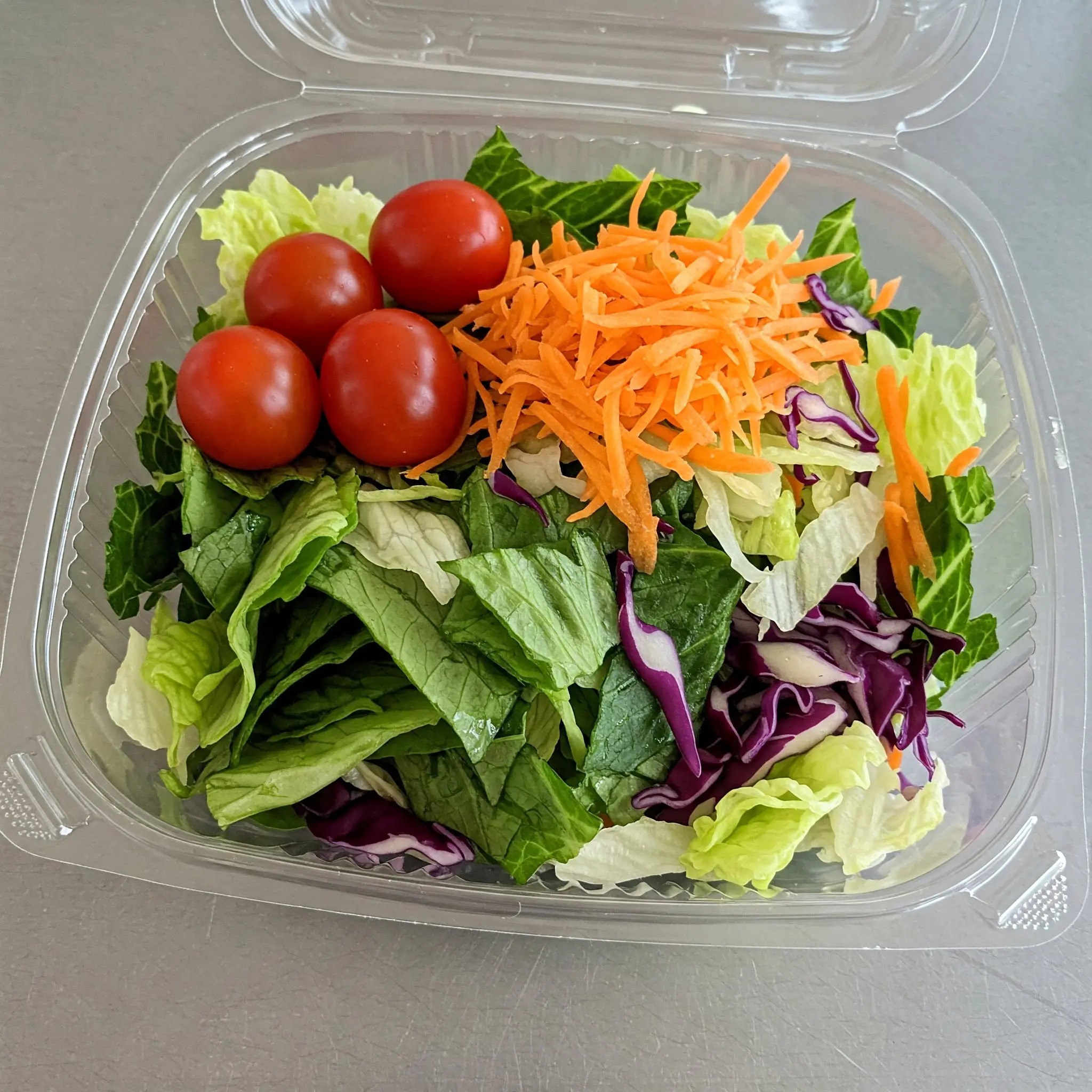 Fresh salad with tomatoes and shredded carrots.