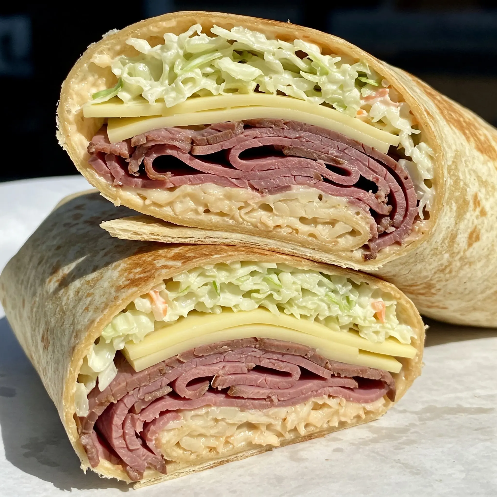 Deli wrap with meat, cheese, and lettuce.