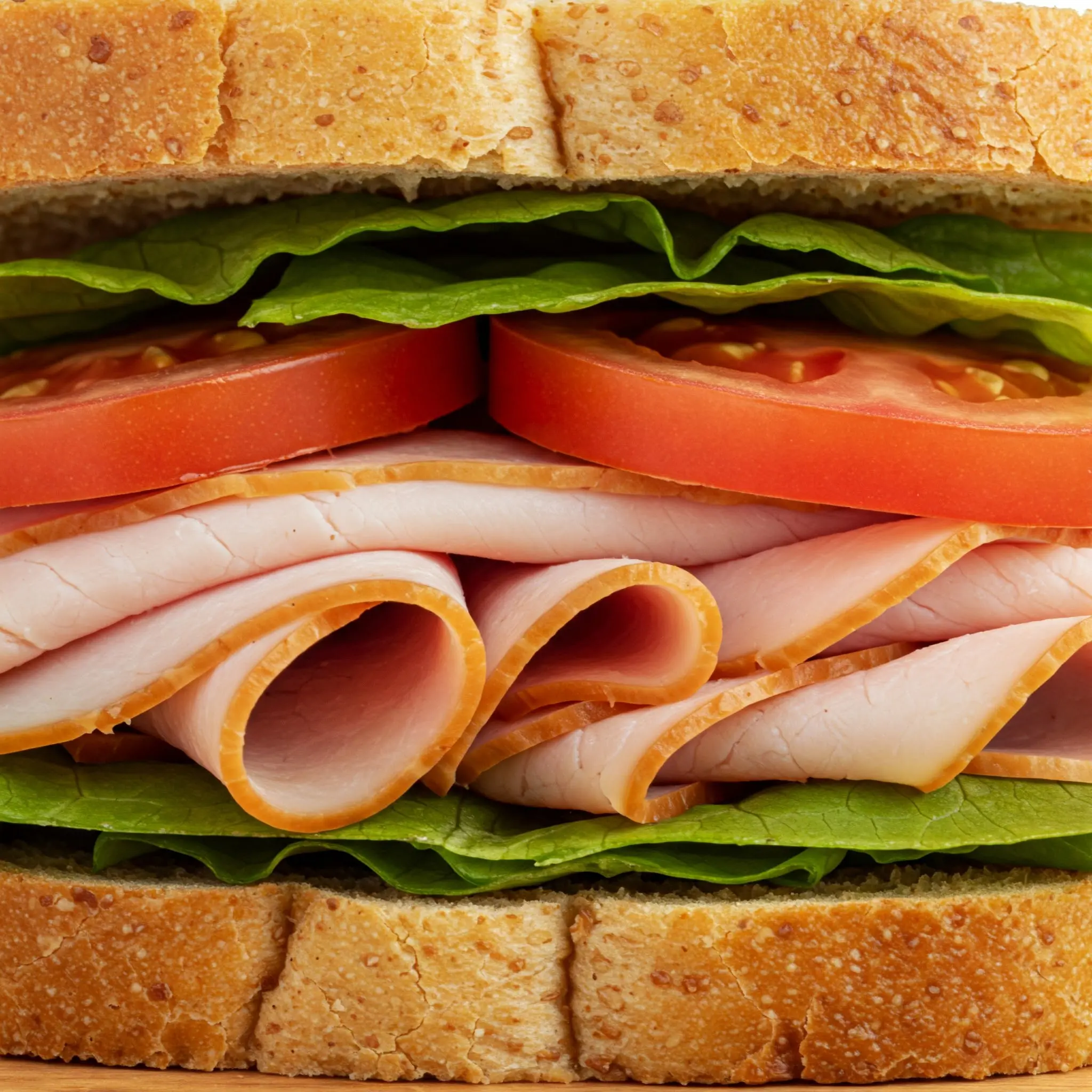 Turkey sandwich with lettuce and tomato slices.