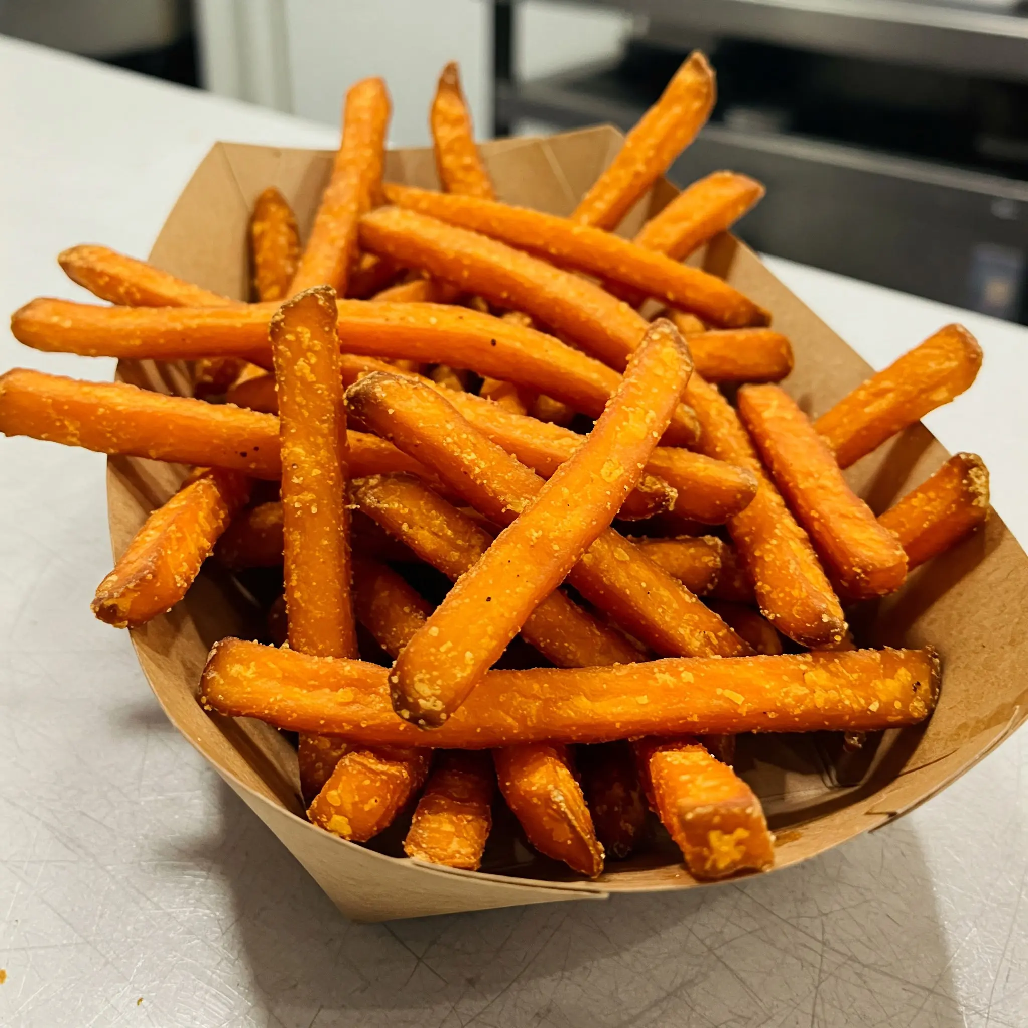 Sweet potato fries in a cardboard tray.