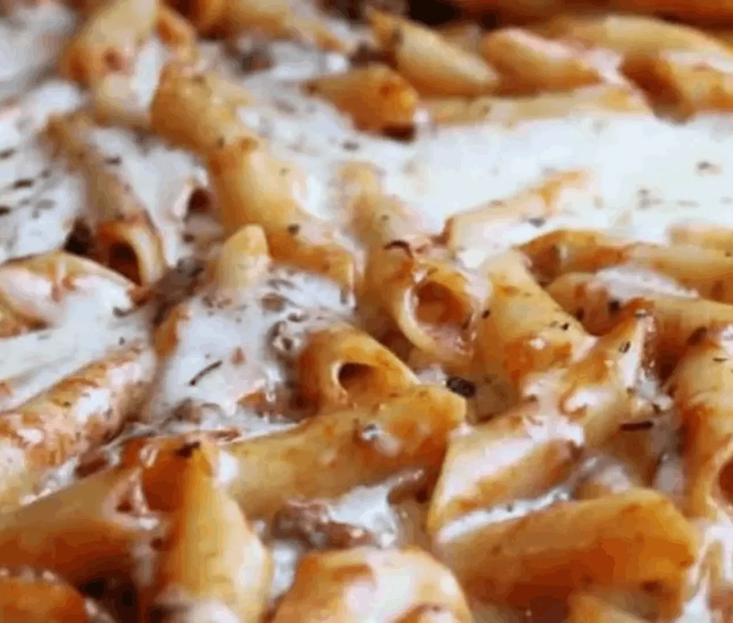 Cheesy pasta with herbs and sauce.