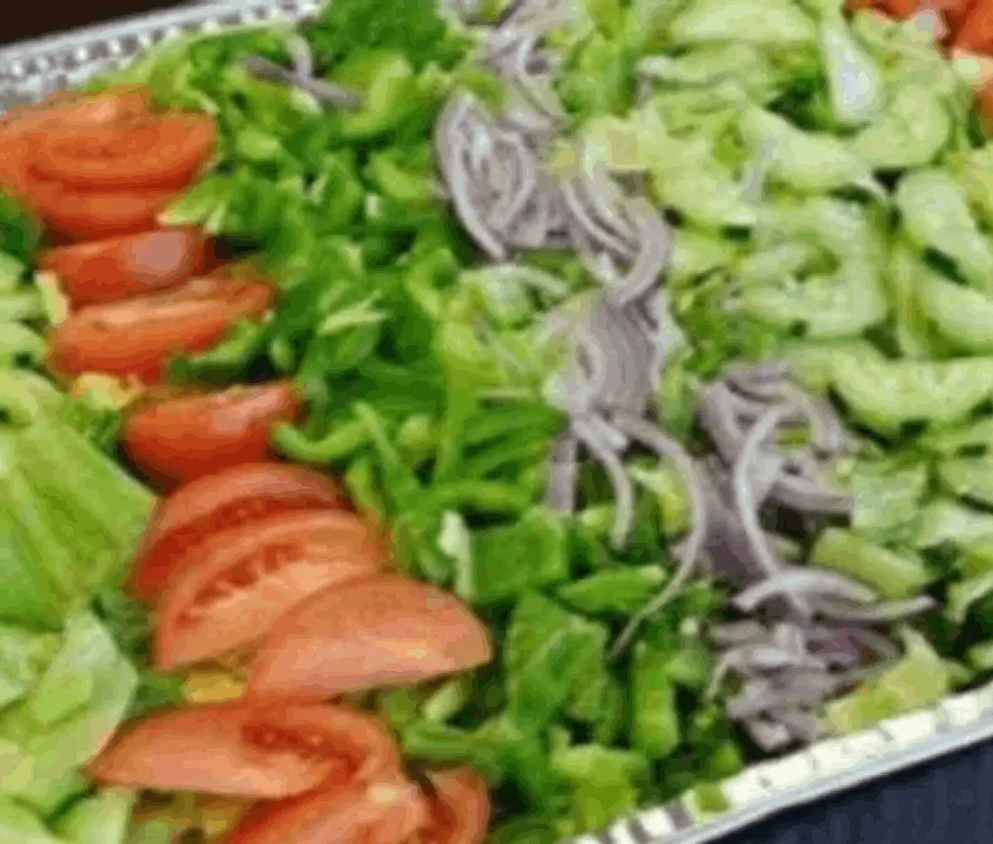Fresh salad platter with sliced vegetables.
