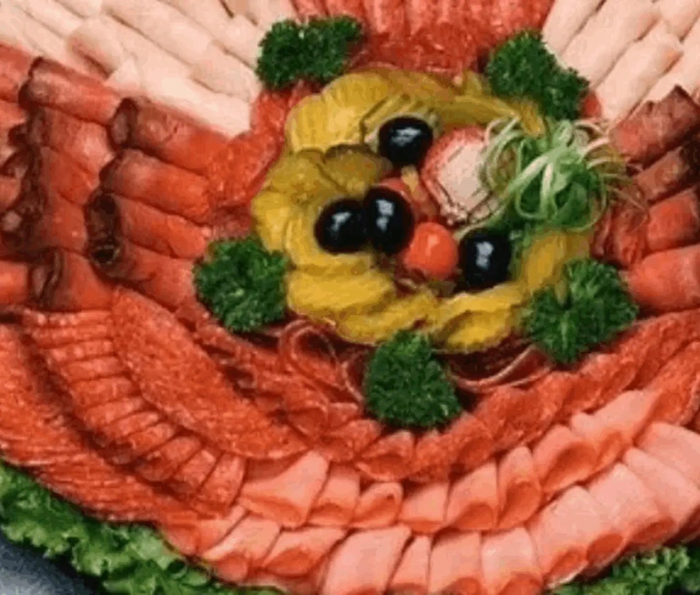 Assorted cold cuts with olives and garnish.