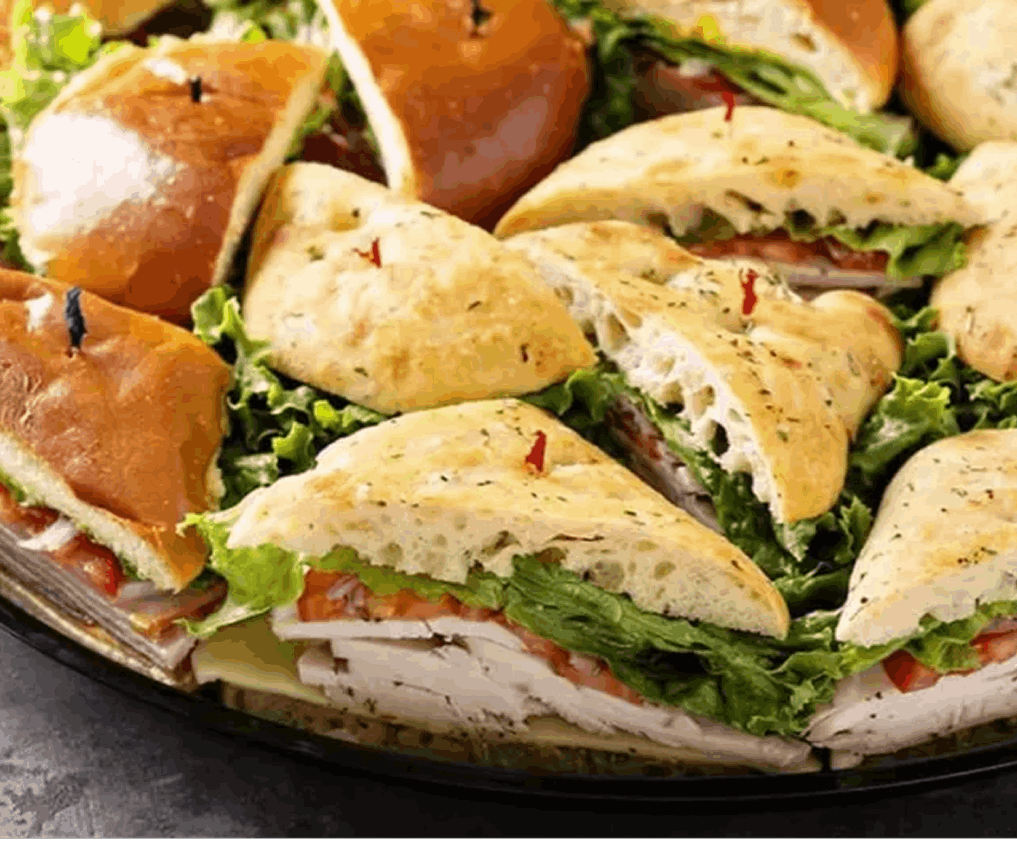 Assorted sandwiches with lettuce on a platter.