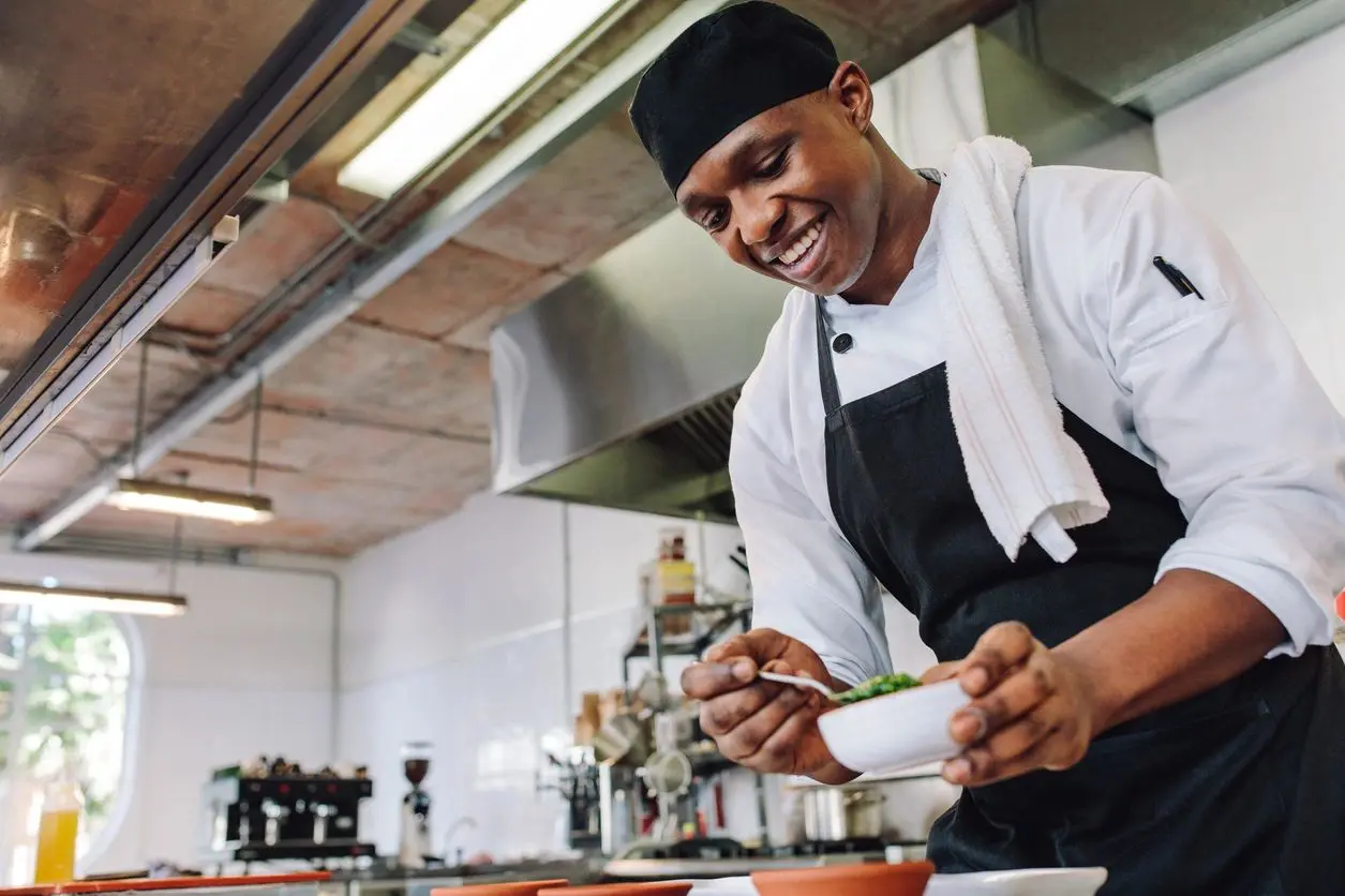 qtq80-59RC79 Chef preparing dish in a professional kitchen.