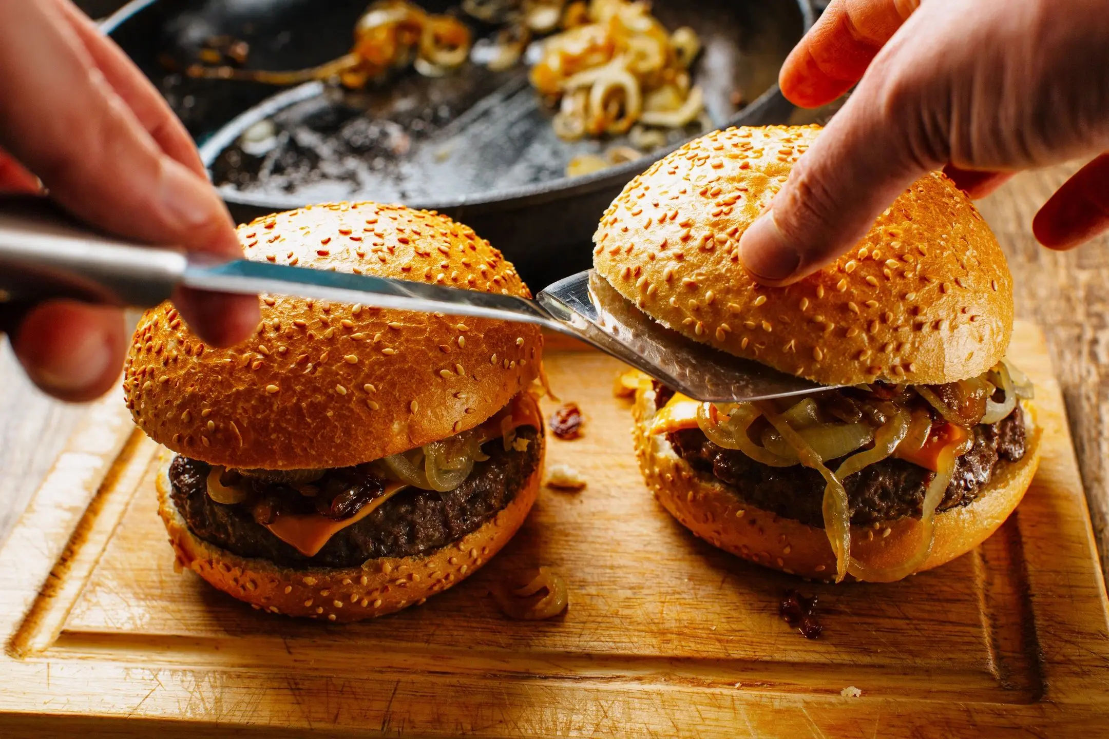 qtq80-dNsDtH Preparing burgers with cheese and grilled onions.